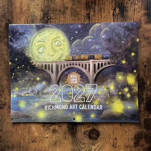 May include: A 2027 Richmond Art Calendar featuring a night scene with a large yellow moon, a train crossing a stone bridge, and glowing fireflies over a river. The text RVA COFFEE STAIN, 2027, and RICHMOND ART CALENDAR are printed on the front.