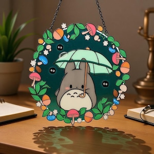 May include: A round, decorative hanging sign featuring a cartoon character holding an umbrella. The sign has a dark green background with colorful mushrooms, leaves, and berries around the edge. The character is gray with a white belly.
