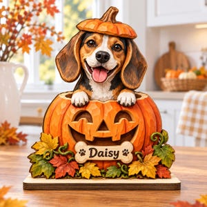 Peut inclure: Une pièce décorative en bois sculpté représentant un chien beagle avec un chapeau citrouille assis dans une citrouille d'Halloween. La base citrouille porte une plaque en forme d'os avec le nom Daisy et des empreintes de pattes.