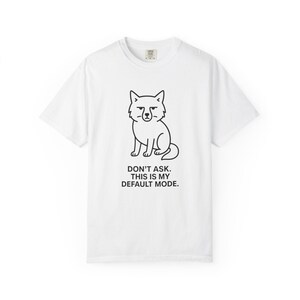 May include: White t-shirt featuring a black line drawing of a fox with a grumpy expression. Below the fox is the text "DON'T ASK. THIS IS MY DEFAULT MODE."