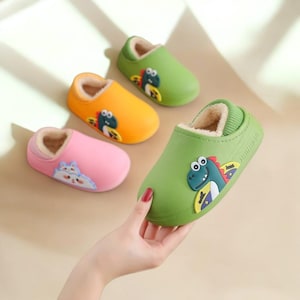 Peut inclure: Quatre pantoufles colorées pour enfants, vertes, oranges et roses. Chaque pantoufle présente un dessin d'animal de dessin animé et un intérieur doux et duveteux. Les pantoufles sont conçues pour une utilisation en intérieur et sont faites d'un matériau durable et facile à nettoyer.