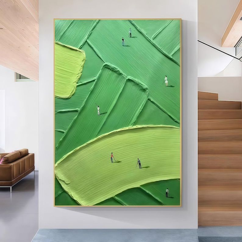 May include: Abstract oil painting on canvas featuring a golf course scene. The artwork uses shades of green with textured brushstrokes to depict the landscape. Miniature figures of golfers are scattered across the course, framed in a gold border.