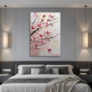 May include: A textured canvas art piece featuring a close-up of pink cherry blossoms on dark branches. The flowers have a 3D effect, with a light pink and white background. The artwork is displayed above a bed.