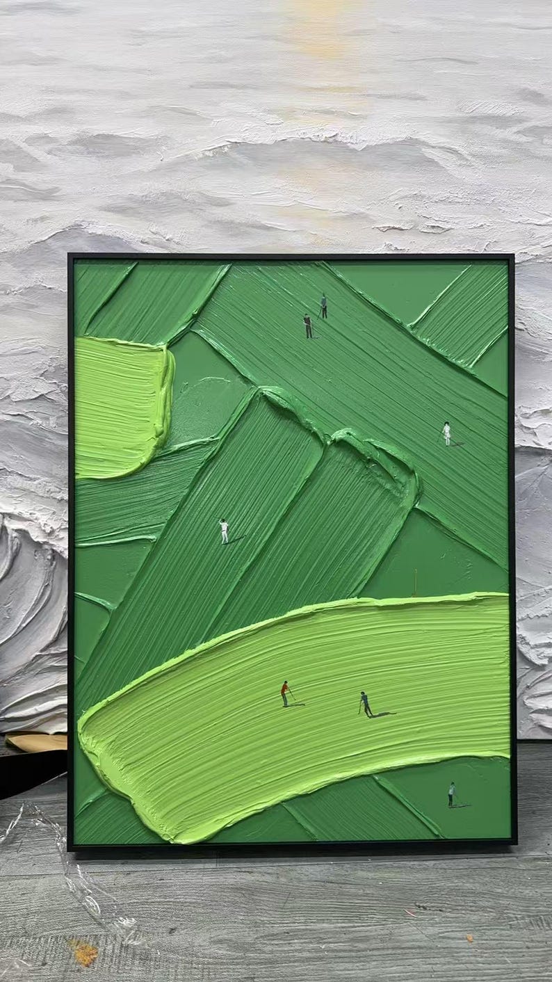 May include: Abstract oil painting of a golf course with a textured, green surface and a black frame. The artwork depicts golfers on the course, with varying shades of green and a white and grey background.