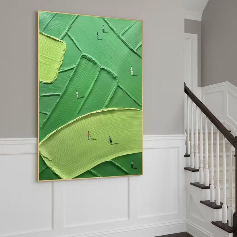 May include: Abstract green textured painting in a gold frame. The artwork depicts a golf course design with miniature figures. The painting uses varying shades of green, creating depth and texture. The figures are dressed in white and red.
