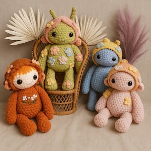 Puede incluir: Cuatro muñecas de ganchillo hechas a mano en varios colores. Una es verde con un sombrero rosa y detalles florales, sentada en una pequeña silla de mimbre. Otra es naranja con un sombrero adornado con flores. Las otras dos son azules y rosas, cada una con un sombrero decorado con flores.