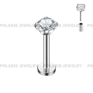 May include: A silver-colored lip piercing stud with a clear, sparkling gemstone. The gemstone is square-shaped with rounded edges, set in a four-prong setting. The post is straight and cylindrical, with a flat disc base.