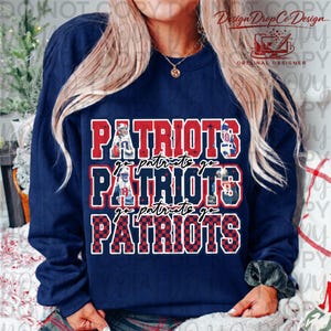 May include: Navy blue sweatshirt featuring the word "PATRIOTS" in red and white block letters, with the words "go patriots go" in a smaller font. The bottom "PATRIOTS" is in a red and black checkered pattern.