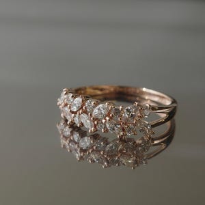 Elegant rose gold diamond ring photographed on mirror surface