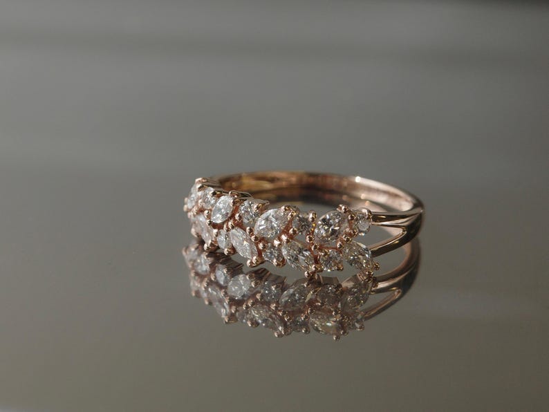Elegant rose gold diamond ring photographed on mirror surface