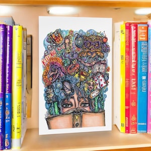 May include: A colorful illustration featuring a person reading a book, with a surreal, detailed artwork above the book. The artwork includes skulls, a monster, and text that reads "Kill Kill" and "Desperado". The image is displayed on a shelf with books.