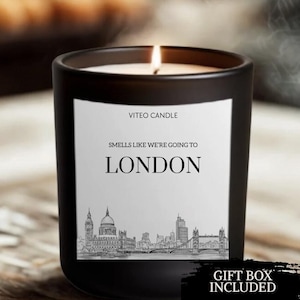 May include: A black matte glass candle with a white label featuring the text VITEO CANDLE, SMELLS LIKE WE'RE GOING TO LONDON, and a black and white line drawing of the London skyline including Big Ben, St. Paul's Cathedral, and Tower Bridge.