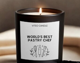 May include: A black candle in a glass jar with a white label featuring the text VITEO CANDLE, WORLD'S BEST PASTRY CHEF, and line art illustrations of a whisk, rolling pin, and spatula, with a lit wick and a GIFT BOX INCLUDED text overlay.