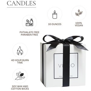The image is a promotional image for candles, featuring a white box with a black ribbon and a candle inside. The text on the image includes details about the candles, such as their vegan status, the number of ounces, and the fact that they are soy wax and cotton wicks. The image also includes a gift box and a handwritten card for sending a message.