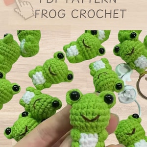 May include: A PDF pattern for crocheting a small green frog amigurumi. The pattern includes instructions for making the frog's body, legs, eyes, and mouth. The image shows several finished frogs, some with white accents on their bellies.