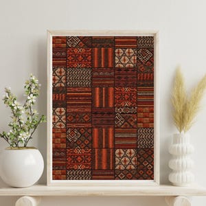 May include: Framed artwork featuring a patchwork design in shades of red, brown, and orange. The artwork is composed of various geometric patterns and textures, creating a visually rich and detailed composition. The frame is a light wood color.