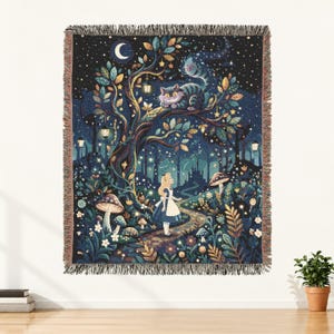 May include: A woven throw blanket featuring a dark night scene with a crescent moon, stars, and a large tree. A striped cat sits on a branch above a person in a blue dress standing on a path. The scene includes glowing lanterns and mushrooms.