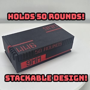 Może przedstawiać: Czarny prostokątny pojemnik z czerwonymi akcentami i napisem "HOLDS 50 ROUNDS!" oraz "STACKABLE DESIGN!". Pojemnik ma również nadruk "9MM" i "50 ROUNDS".