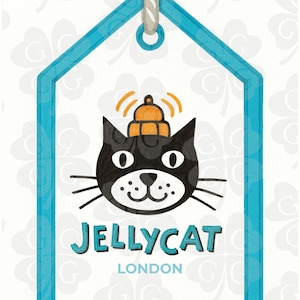 May include: A white tag with a teal border and a gray rope. The tag features a black cat illustration with an orange bell on its head. The text "JELLYCAT LONDON" is below the cat.