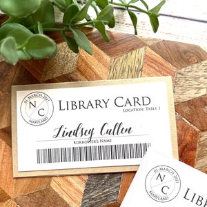 May include: A brown library card with the text "LIBRARY CARD" and "LOCATION: TABLE 1". The card also has a black and white stamp with the text "01-MARCH-2021", "N", "C", and "MARYLAND". The name "Lindsey Cullen" is written in cursive below the text "LIBRARY CARD".