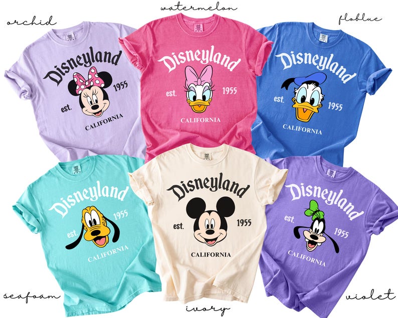 Puede incluir: Seis camisetas de colores con el logotipo de Disneyland y personajes de Disney. Los colores incluyen orqu&iacute;dea, sand&iacute;a, azul, verde mar, marfil y violeta. Cada camiseta tiene el texto "Disneyland est. 1955 CALIFORNIA".
