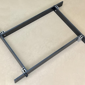 May include: A black metal frame with four adjustable corners. The frame is made of metal and has a black finish. The corners are adjustable and can be used to create a variety of shapes.