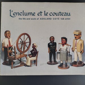 May include: A book cover with the title "L'enclume et le couteau" and the text "the life and work of ADELARD COTE folk artist." The cover features wooden folk art figurines, including a man with a spinning wheel, a woman, and other figures.