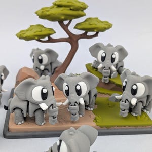 Könnte beinhalten: Eine Ansammlung grauer Cartoon-Elefantenfiguren mit großen weißen Augen und Stoßzähnen. Die Elefanten sind um einen Miniaturbaum mit grünem Laub und einem braunen Stamm angeordnet. Die Basis ist eine braune und grüne Landschaft.