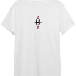 A white t-shirt with a small red and black design on the front.