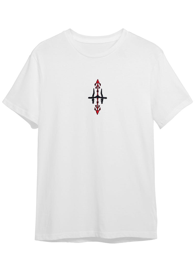 A white t-shirt with a small red and black design on the front.