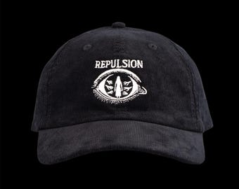 May include: Black corduroy baseball cap with the word "REPLUSION" in white above a white eye graphic. The eye graphic has a figure inside with leaves. The cap has a curved brim and a button on top.