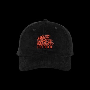 Puede incluir: Una gorra de béisbol de pana negra con un gráfico bordado en rojo de un rostro estilizado que grita, con líneas detalladas y el texto TETSUO en letras mayúsculas rojas centrado en el panel frontal sobre la visera curva.
