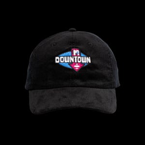 May include: A black corduroy baseball cap featuring an embroidered logo on the front. The logo consists of a blue diamond shape with a pink downward-pointing arrow and the white text DOWNTOWN, topped with a small MTV logo icon.
