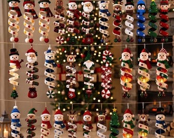 May include: A collection of 35 hanging Christmas ornaments featuring various characters like snowmen, Santa Claus, reindeer, and elves, each attached to a spiral-shaped ribbon with festive patterns and small decorative accents at the bottom.