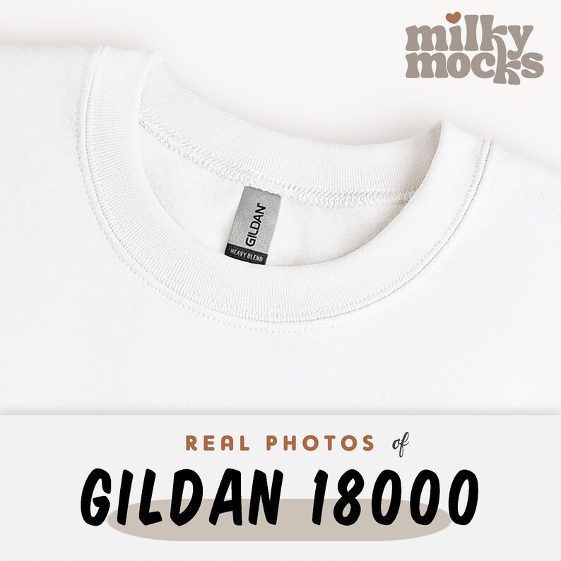 K&ouml;nnte beinhalten: Nahaufnahme eines wei&szlig;en Gildan 18000 Sweatshirts. Das Sweatshirt hat einen Rundhalsausschnitt und ein Etikett mit der Aufschrift "GILDAN HEAVY BLEND". Der Text "REAL PHOTOS of GILDAN 18000" befindet sich am unteren Bildrand.