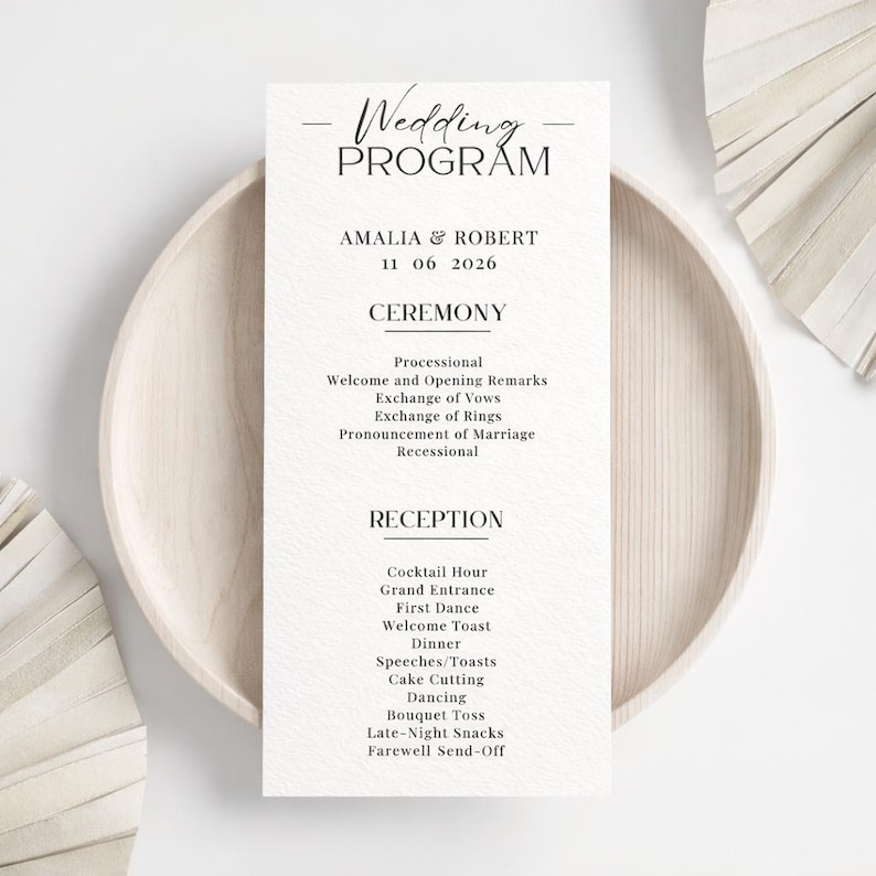 K&ouml;nnte beinhalten: Ein Hochzeitsprogramm mit dem Titel "Wedding Program" oben. Das Programm enth&auml;lt die Namen "AMALIA & ROBERT" und das Datum "11 06 2026". Das Programm listet die Zeremonie- und Empfangsereignisse auf, gedruckt auf strukturiertem wei&szlig;em Papier.