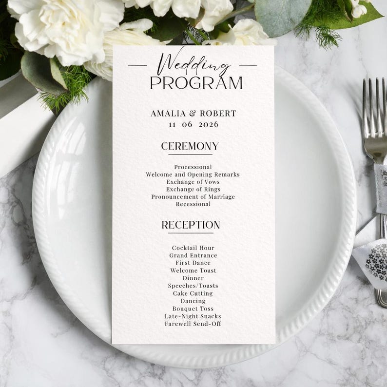 K&ouml;nnte beinhalten: Ein Hochzeitsprogramm auf einem wei&szlig;en Teller mit einem Blumengesteck. Das Programm listet die Details der Zeremonie und des Empfangs auf, einschlie&szlig;lich der Namen Amalia & Robert und des Datums 11 06 2026. Das Programm ist schwarz und wei&szlig;.