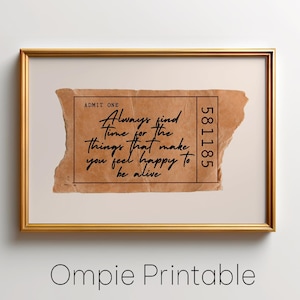 Puede incluir: Una impresión enmarcada con un marco dorado. La impresión presenta un boleto marrón rasgado con las palabras "Always find time for the things that make you feel happy to be alive." El boleto también tiene el número 581185.