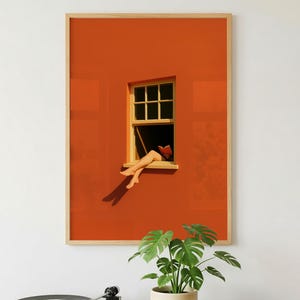 Könnte beinhalten: Ein gerahmter Kunstdruck zeigt eine Person, die sich an einem Fenster entspannt, mit ausgestreckten Beinen. Das Kunstwerk zeigt eine orangefarbene Wand, einen Holzfensterrahmen und einen Holzrahmen um den Druck. Ein Plattenspieler und eine Topfpflanze befinden sich im Vordergrund.