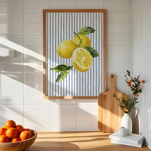 May include: A framed watercolor print featuring lemons and green leaves against a blue and white striped background. The wooden frame complements the bright yellow fruit. The artwork adds a touch of freshness to any kitchen or dining area.