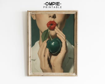 May include: Framed vintage art print featuring a person with red lips holding a cherry. The artwork has a green background and is framed in a gold-toned frame. The print is from OMPIE PRINTABLE.