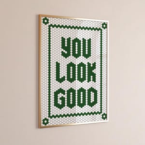Könnte beinhalten: Gerahmtes Wandbild mit den Worten "YOU LOOK GOOD" in grünen sechseckigen Fliesen. Der Text ist auf einem weißen Hintergrund aus sechseckigen Fliesen zentriert, umrahmt von einem grünen Rand und einem goldfarbenen Rahmen.
