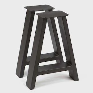 May include: Two black metal table legs with a modern, minimalist design. Each leg has a rectangular top with pre-drilled holes, a sturdy angled support, and a horizontal crossbar for added stability. The legs are suitable for various table projects.