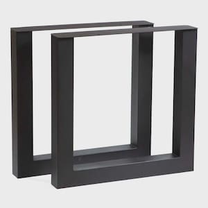 May include: Two black, square-shaped metal table legs. Each leg is a hollow rectangle, with a flat top and bottom, and four vertical supports. The legs are designed for supporting a tabletop and have a modern, minimalist aesthetic.
