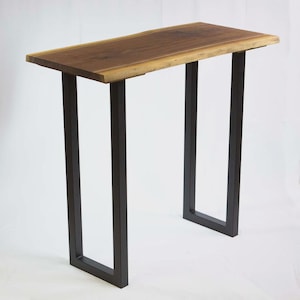 May include: A rectangular console table with a live edge walnut top and dark metal legs. The table's top is approximately 48 inches long and 12 inches wide. The legs are a dark, matte finish, creating a modern, minimalist aesthetic.