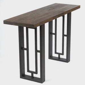 May include: A rectangular console table with a dark brown wooden top and a black metal geometric base. The table has a modern design and is suitable for entryways or living rooms.