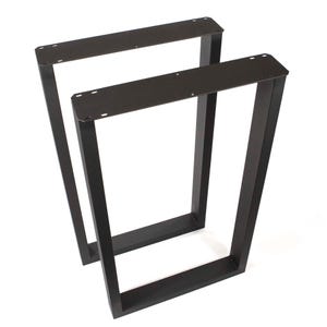 May include: A pair of matte black metal table legs with a rectangular frame design. Each leg features a flat top mounting plate with pre-drilled holes for attachment, connected to two vertical supports and a horizontal base bar for stability.