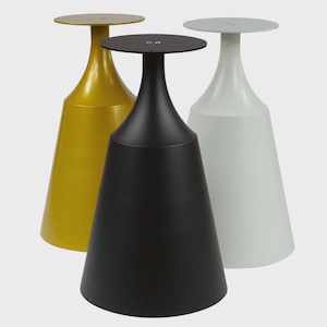 May include: Three modern accent tables in yellow, black, and white. Each table has a conical base and a round tabletop. The tables are made of metal and have a minimalist design. The tables are suitable for a living room or bedroom.