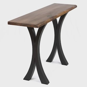 May include: A wooden console table with a dark brown tabletop and black, curved legs. The tabletop has a natural edge, and the legs form an X-shape. The table is designed for a living room or entryway.