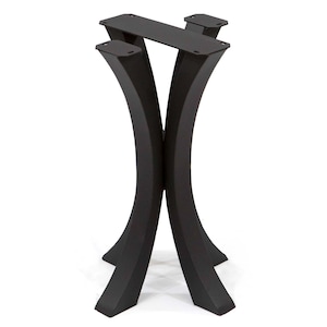 May include: Black metal table base with a modern design. The base features two curved legs that intersect, supporting a rectangular top with mounting plates. The legs are approximately 28 inches tall.